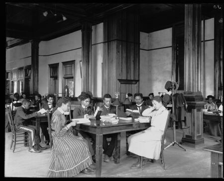 digitized image of [Interior view of library reading room with male and female students sitting at tables, reading, at the Tuskegee Institute]